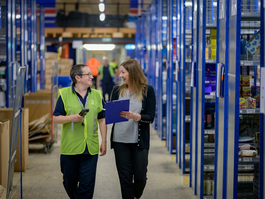 Two people walking a warehouse aisle